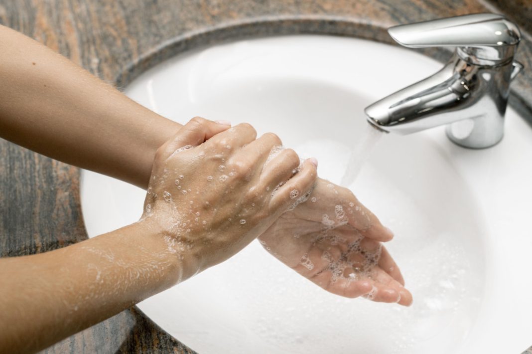 mulher lavando as mãos com torneira desligada para para economizar água