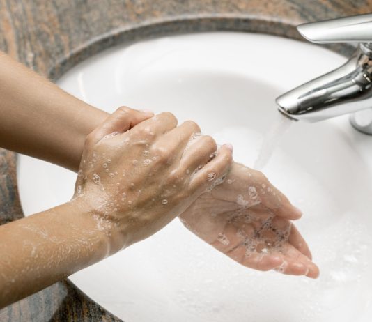mulher lavando as mãos com torneira desligada para para economizar água